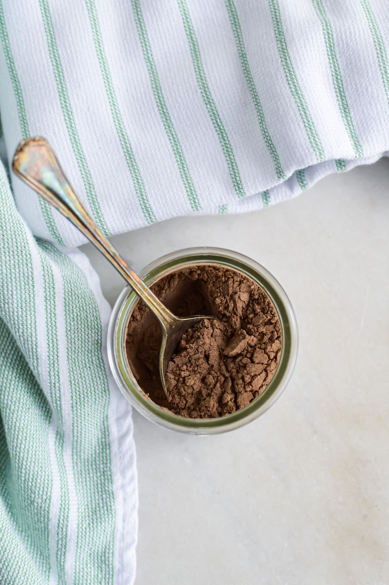 DIY Dry Shampoo for dark hair in a jar on a white table.