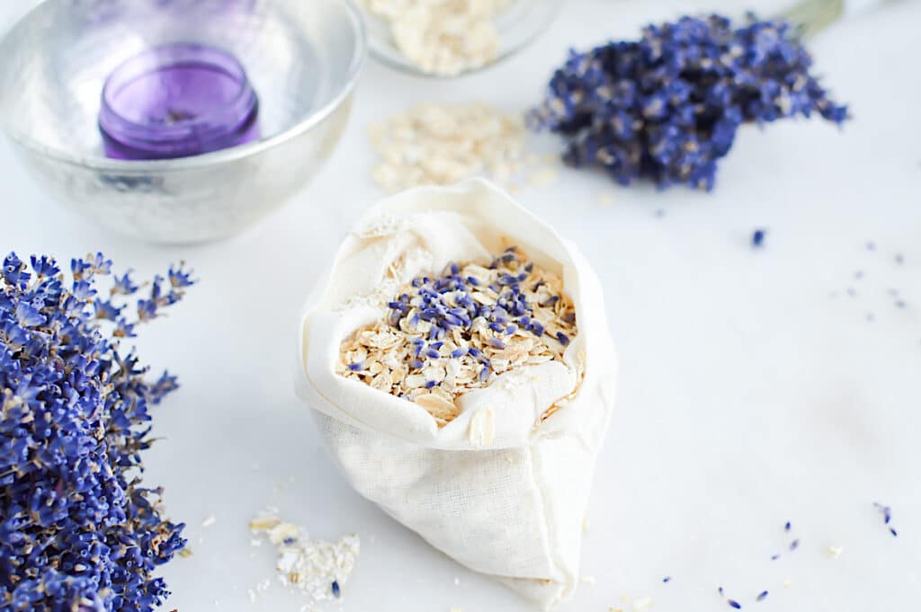 A bag filled with lavender flowers and oats to be used as an Oat Bath Soak.