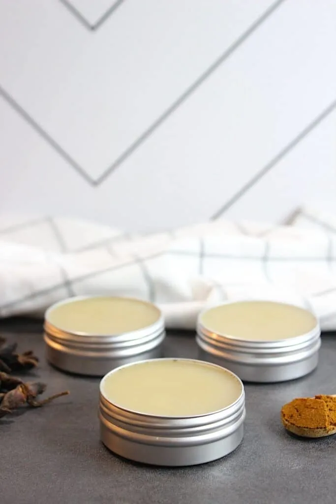 Three tins of star anise salve sitting on a table.