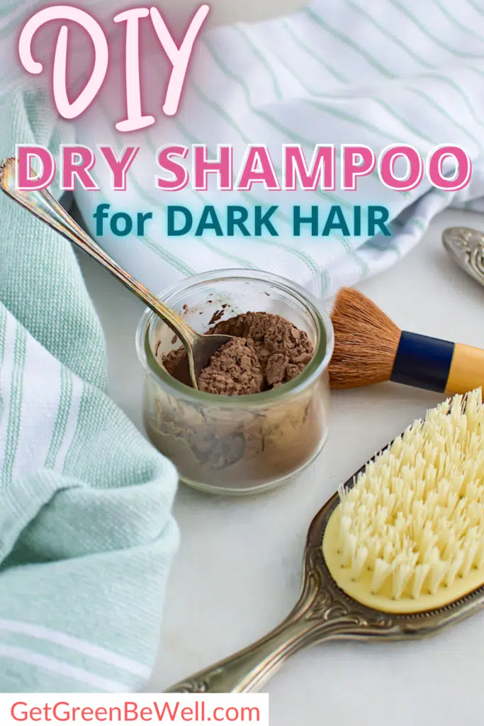 Image showing a DIY dry shampoo for dark hair setup. It includes a jar with powder, a spoon, a brush, a striped towel, and a hairbrush placed on a white surface.